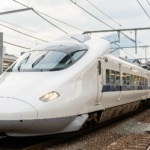 Photorealistic image of a Shinkansen bullet train in motion, showcasing advanced technology.
